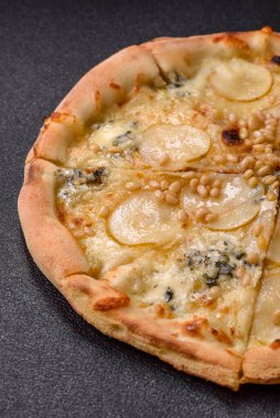 Armut, gorgonzola peyniri ve fındıklı, koyu beton zemin üzerinde lezzetli tatlı pizza.
