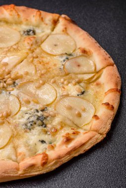 Armut, gorgonzola peyniri ve fındıklı, koyu beton zemin üzerinde lezzetli tatlı pizza.