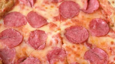 Sosisli, peynirli, domatesli, tuzlu ve baharatlı biberli pizza.