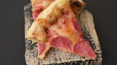 Sosisli, peynirli, domatesli, tuzlu ve baharatlı biberli pizza.