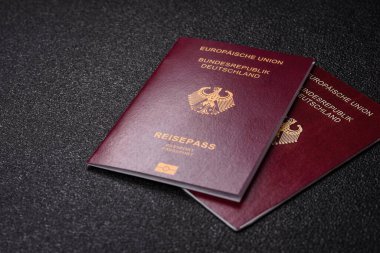 Tasarımınız için bir duvar kağıdı olarak siyah desenli arka plana karşı Alman vatandaşı pasaportu