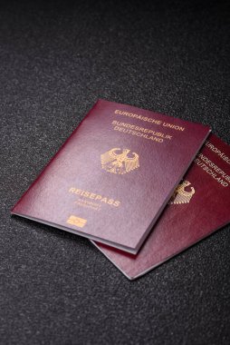 Tasarımınız için bir duvar kağıdı olarak siyah desenli arka plana karşı Alman vatandaşı pasaportu