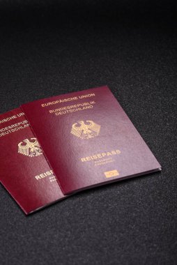 Tasarımınız için bir duvar kağıdı olarak siyah desenli arka plana karşı Alman vatandaşı pasaportu