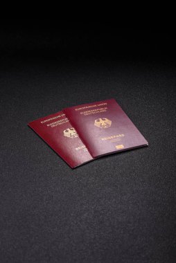 Tasarımınız için bir duvar kağıdı olarak siyah desenli arka plana karşı Alman vatandaşı pasaportu