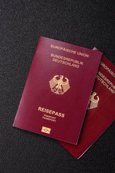 Tasarımınız için bir duvar kağıdı olarak siyah desenli arka plana karşı Alman vatandaşı pasaportu