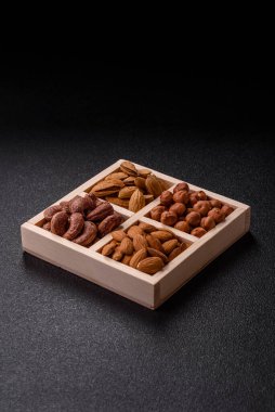 İçinde fındık bademleri, kabuklu bademler, cevizler, fındıklar olan tahta kutu.