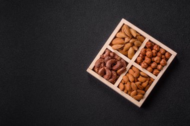 İçinde fındık bademleri, kabuklu bademler, cevizler, fındıklar olan tahta kutu.