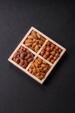 İçinde fındık bademleri, kabuklu bademler, cevizler, fındıklar olan tahta kutu.