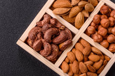 İçinde fındık bademleri, kabuklu bademler, cevizler, fındıklar olan tahta kutu.