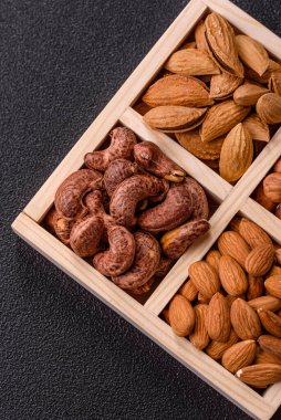 İçinde fındık bademleri, kabuklu bademler, cevizler, fındıklar olan tahta kutu.
