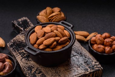 Koyu beton arka planda kavrulmuş ya da soyulmuş bademler.