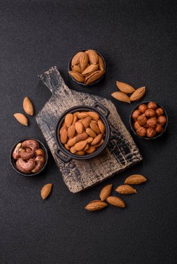 Koyu beton arka planda kavrulmuş ya da soyulmuş bademler.