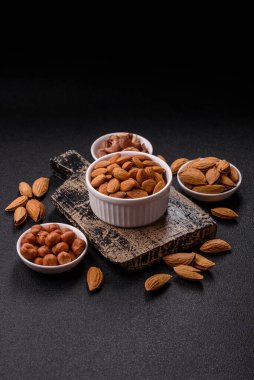 Koyu beton arka planda kavrulmuş ya da soyulmuş bademler.