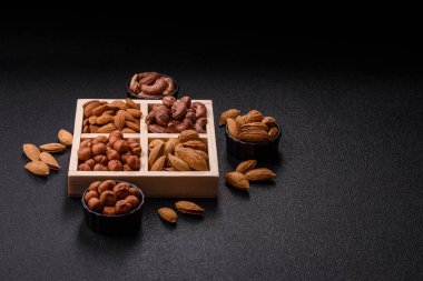İçinde fındık bademleri, kabuklu bademler, cevizler, fındıklar olan tahta kutu.