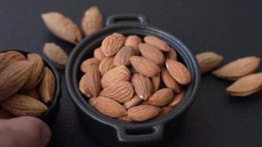 Koyu beton arka planda kavrulmuş ya da soyulmuş bademler.