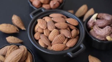 Koyu beton arka planda kavrulmuş ya da soyulmuş bademler.