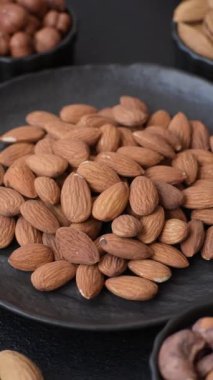 Koyu beton arka planda kavrulmuş ya da soyulmuş bademler.