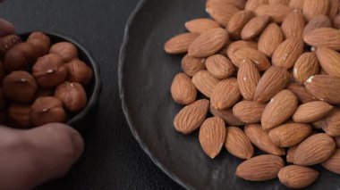 Koyu beton arka planda kavrulmuş ya da soyulmuş bademler.