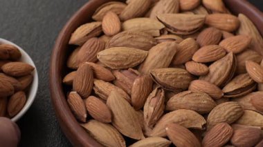 Kavrulmuş ya da çiğ badem fıstığı kabukta koyu beton arka planda.