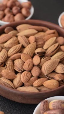 Kavrulmuş ya da çiğ badem fıstığı kabukta koyu beton arka planda.