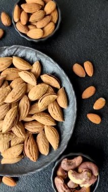 Kavrulmuş ya da çiğ badem fıstığı kabukta koyu beton arka planda.