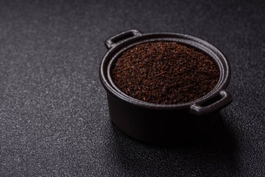 Siyah çay, koyu beton arka planda kasede ezilmiş.