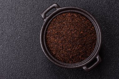 Siyah çay, koyu beton arka planda kasede ezilmiş.