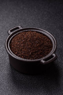 Siyah çay, koyu beton arka planda kasede ezilmiş.