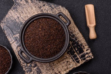 Siyah çay, koyu beton arka planda kasede ezilmiş.