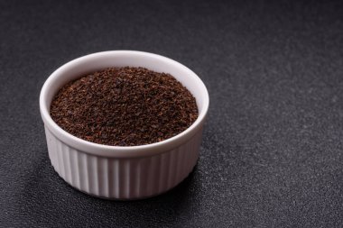 Siyah çay, koyu beton arka planda kasede ezilmiş.
