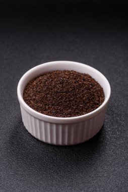 Siyah çay, koyu beton arka planda kasede ezilmiş.