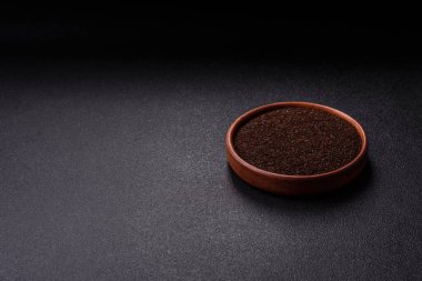 Siyah çay, koyu beton arka planda kasede ezilmiş.