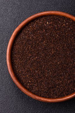 Siyah çay, koyu beton arka planda kasede ezilmiş.