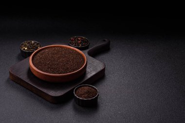 Siyah çay, koyu beton arka planda kasede ezilmiş.