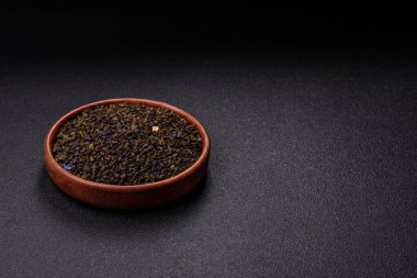 Kuru yeşil çay, soya somunu, knapweed yaprakları koyu beton arka planda.