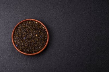 Kuru yeşil çay, soya somunu, knapweed yaprakları koyu beton arka planda.