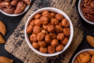 Koyu beton arka planda kabuksuz çiğ fındık.