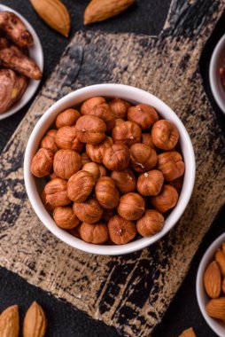 Koyu beton arka planda kabuksuz çiğ fındık.