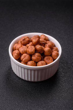 Koyu beton arka planda kabuksuz çiğ fındık.