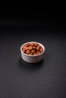 Koyu beton arka planda kabuksuz çiğ fındık.