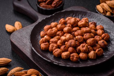 Koyu beton arka planda kabuksuz çiğ fındık.