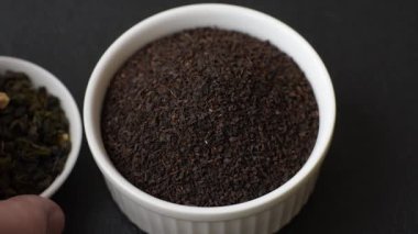 Siyah çay, koyu beton arka planda kasede ezilmiş.