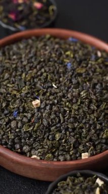 Kuru yeşil çay, soya somunu, knapweed yaprakları koyu beton arka planda.