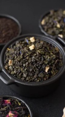 Kuru yeşil çay, soya somunu, knapweed yaprakları koyu beton arka planda.