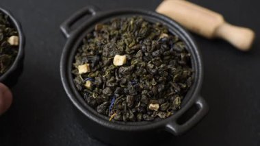 Kuru yeşil çay, soya somunu, knapweed yaprakları koyu beton arka planda.