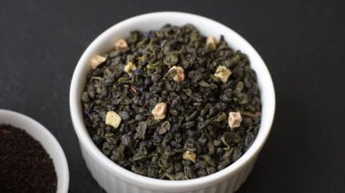 Kuru yeşil çay, soya somunu, knapweed yaprakları koyu beton arka planda.