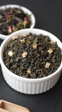 Kuru yeşil çay, soya somunu, knapweed yaprakları koyu beton arka planda.