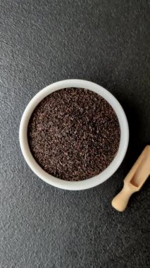 Siyah çay, koyu beton arka planda kasede ezilmiş.