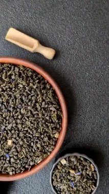 Kuru yeşil çay, soya somunu, knapweed yaprakları koyu beton arka planda.