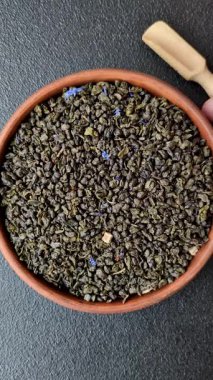 Kuru yeşil çay, soya somunu, knapweed yaprakları koyu beton arka planda.